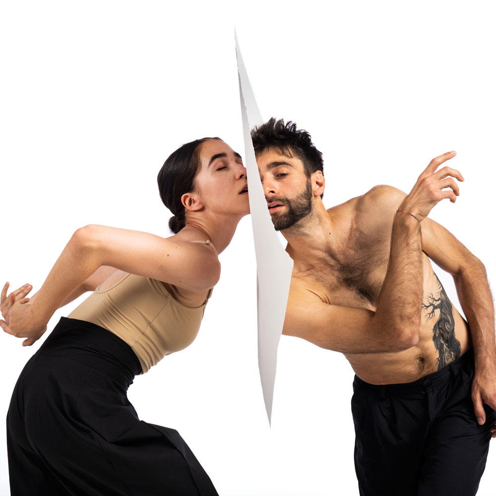 Dance artists from Wen Wei Dance pose with paper between them