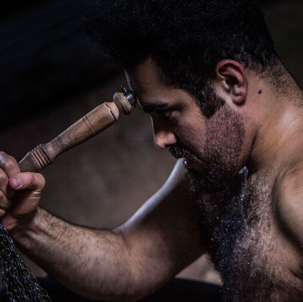 Dance artist Arash Khakpour poses with a wooden dowel resting on his forehead